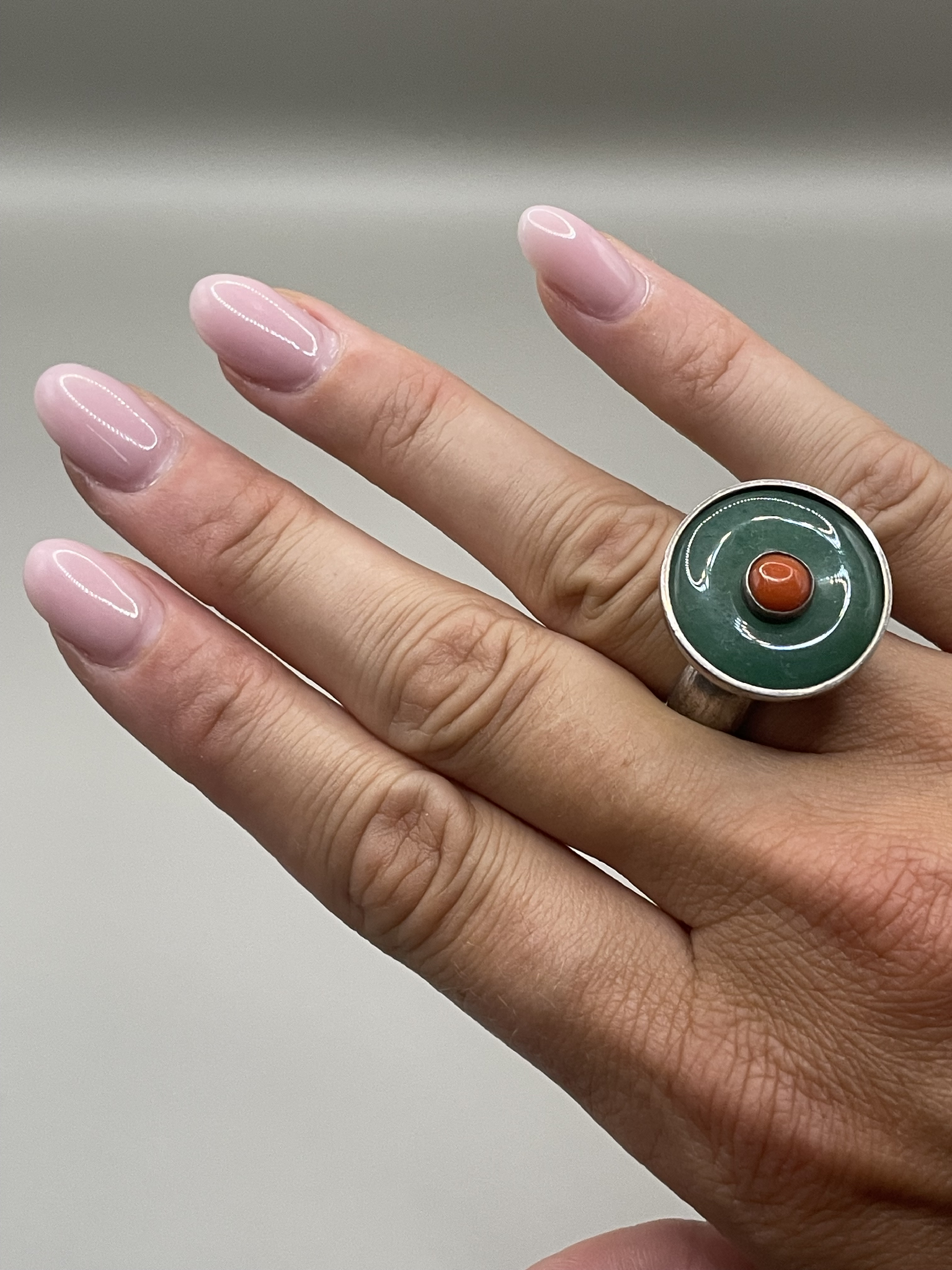 Silver ring with green enamel and red stone